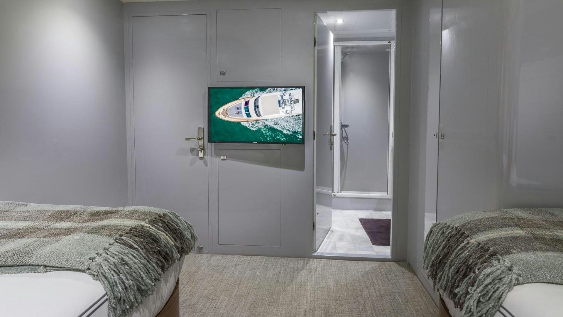 a bedroom with a tv on the wall aboard NIRVANA Yacht for Sale