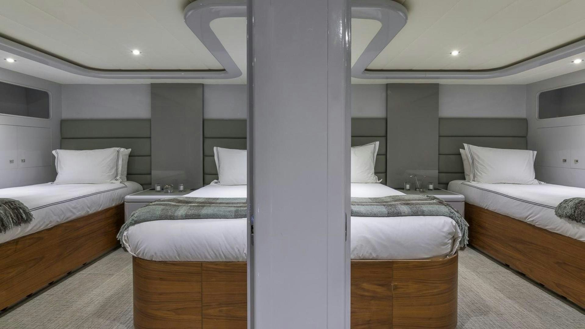 a room with beds and a large mirror aboard NIRVANA Yacht for Sale