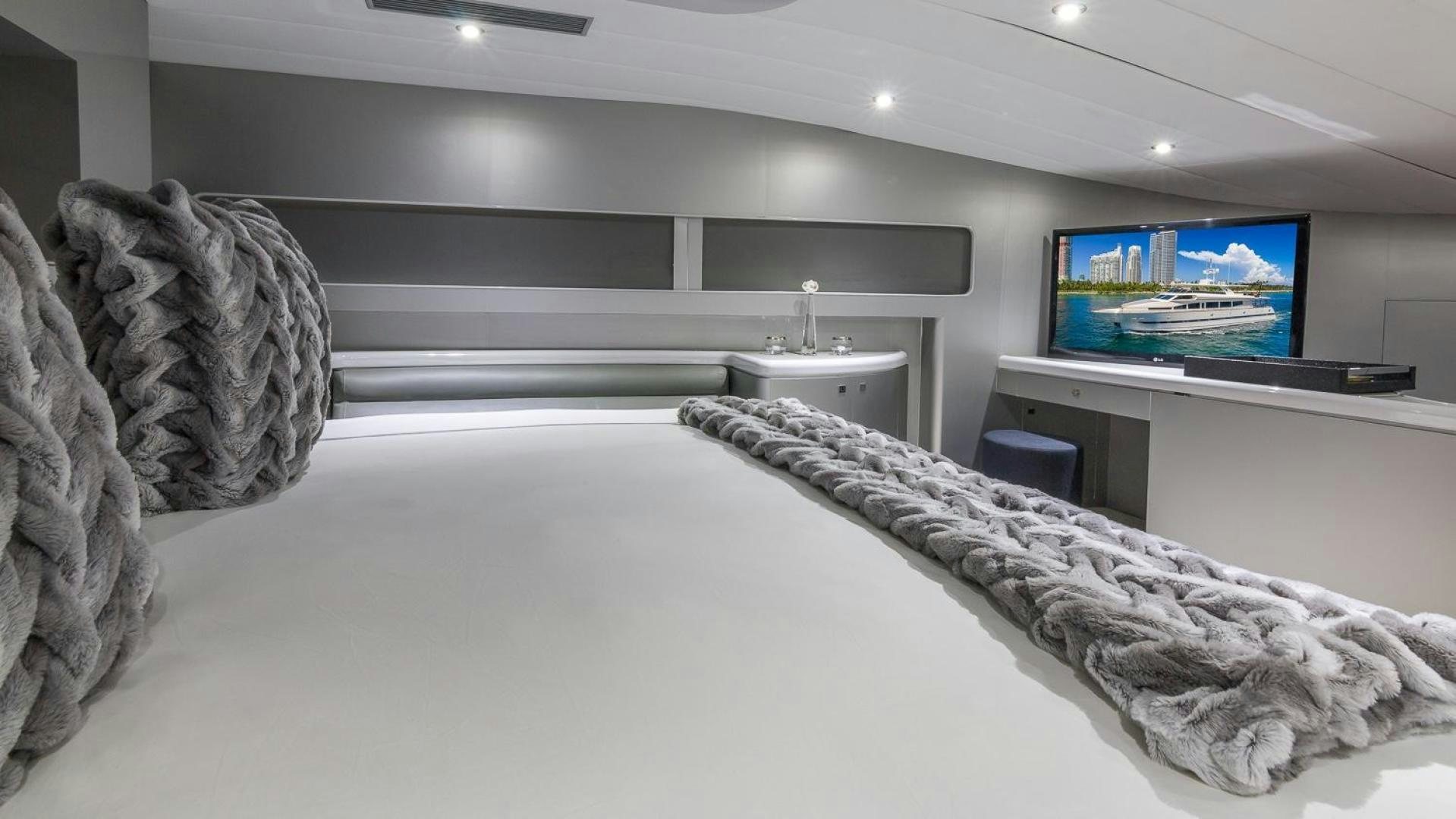 a room with a large bed and a tv on the wall aboard NIRVANA Yacht for Sale