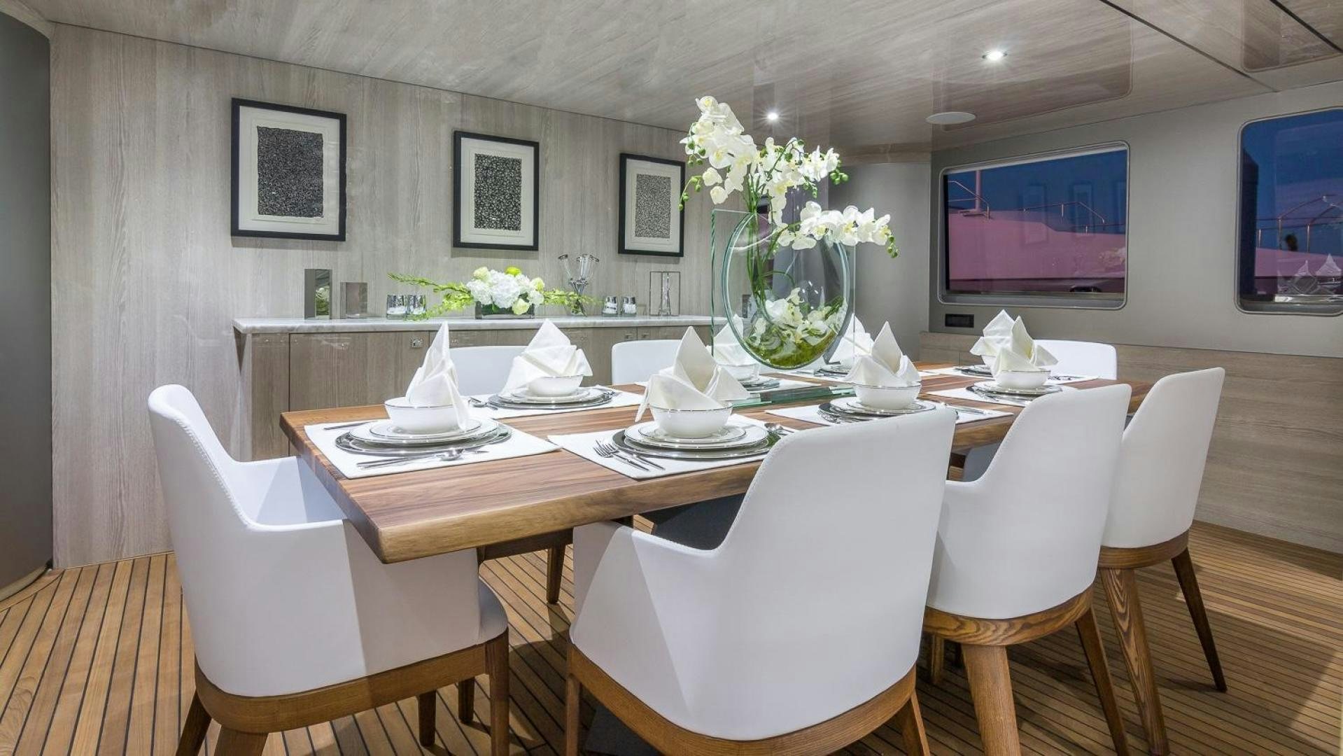 a table with chairs and a vase with flowers on it aboard NIRVANA Yacht for Sale