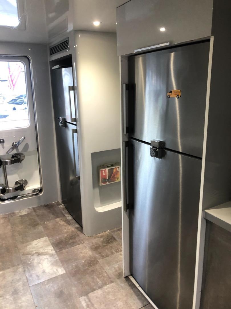 a stainless steel refrigerator in a kitchen aboard NIRVANA Yacht for Sale