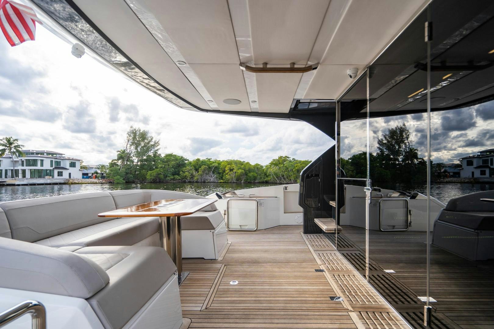 a deck with a flag and a building with trees and plants aboard BLIND DATE Yacht for Sale