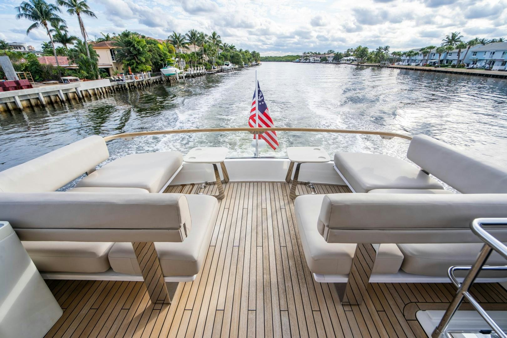 a deck with chairs on it and a flag on the side aboard BLIND DATE Yacht for Sale