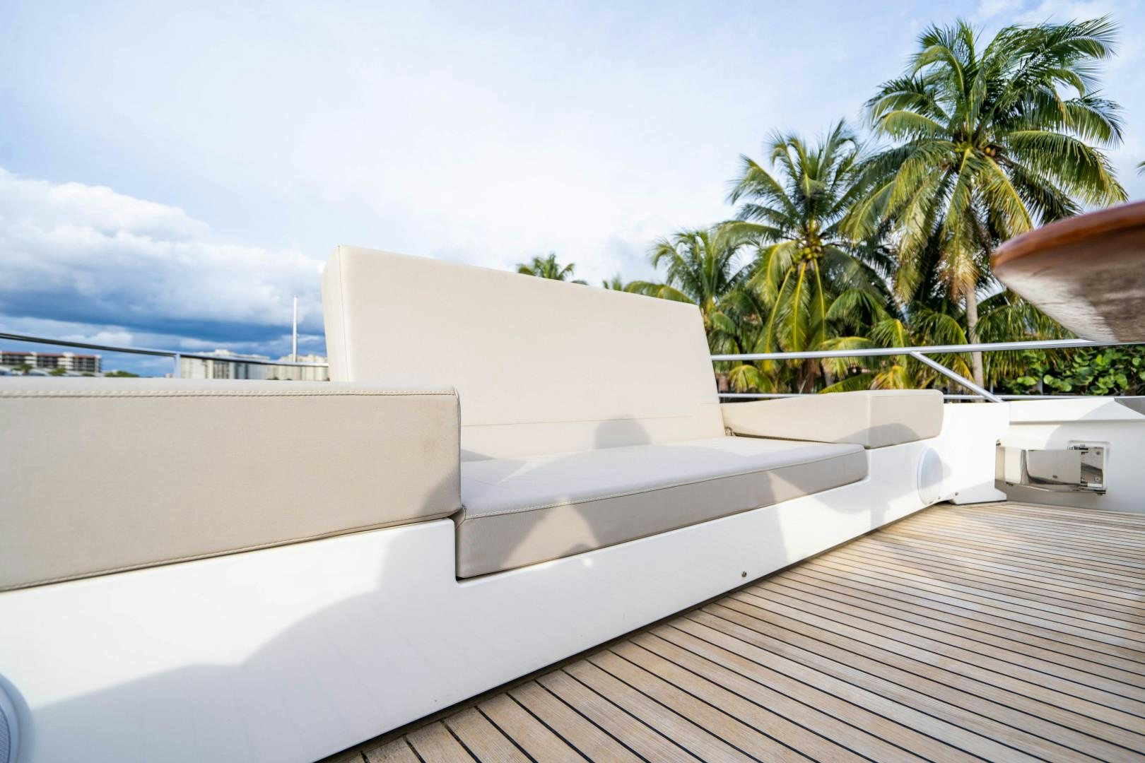 a white building with a deck and palm trees aboard BLIND DATE Yacht for Sale