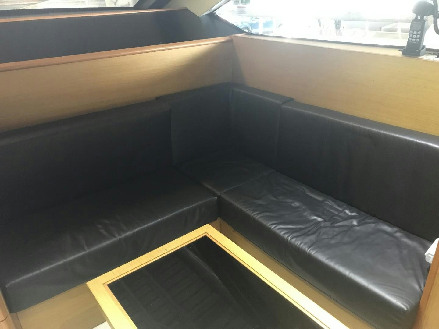 a black couch on a wooden floor aboard BLUWATER Yacht for Sale