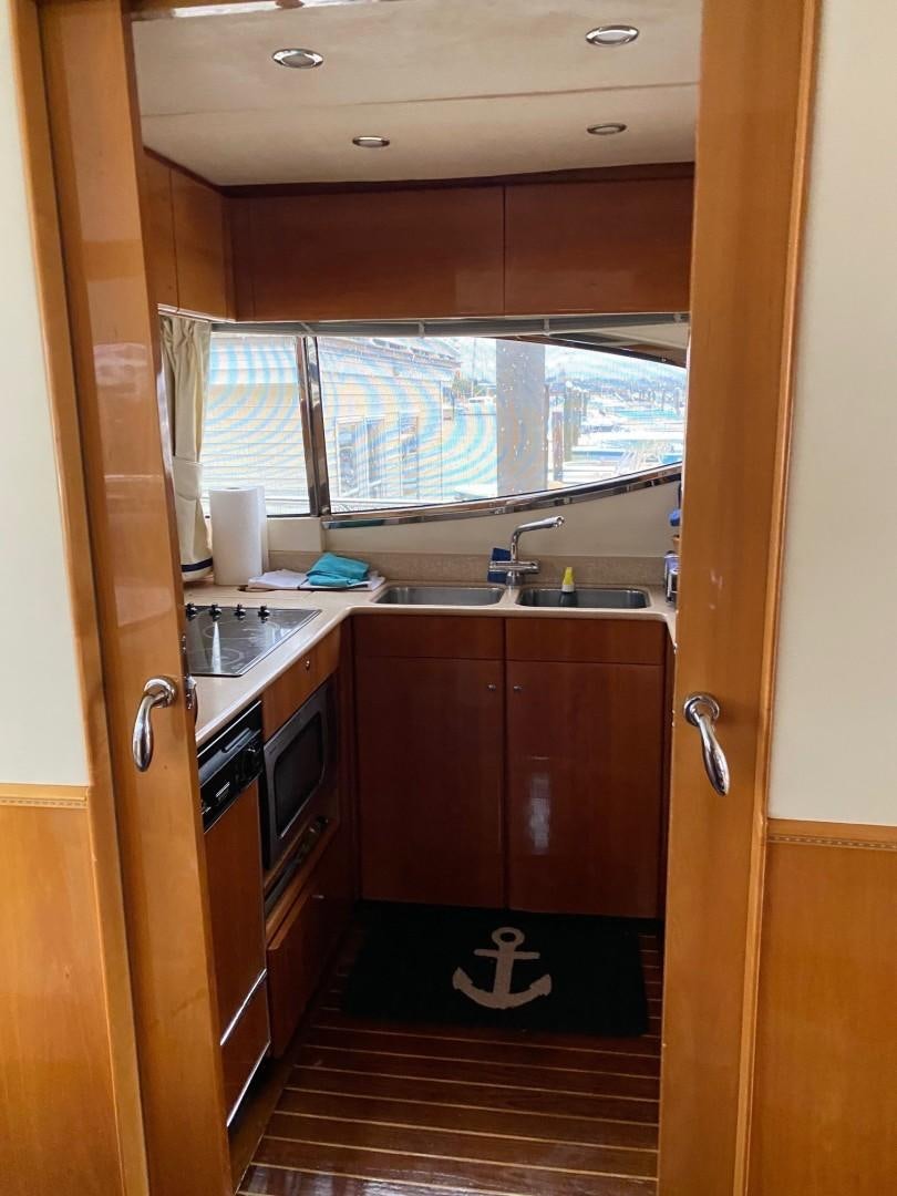 a kitchen with wooden cabinets aboard JOIE DU ROI Yacht for Sale