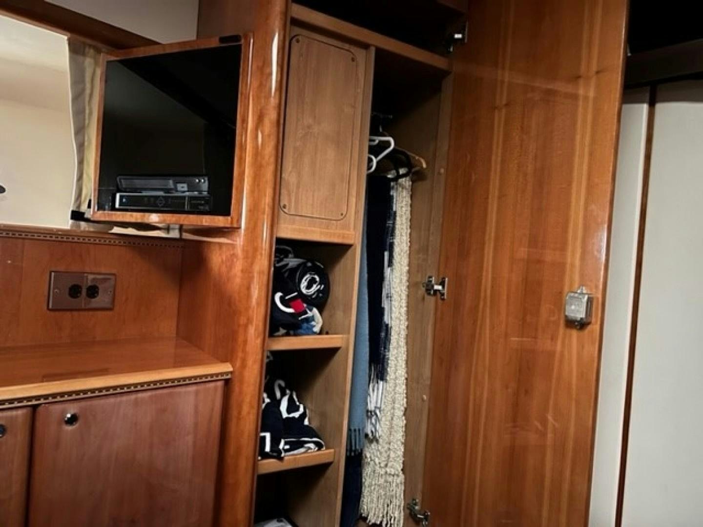 a closet with a television and a shelf with a curtain aboard JOIE DU ROI Yacht for Sale