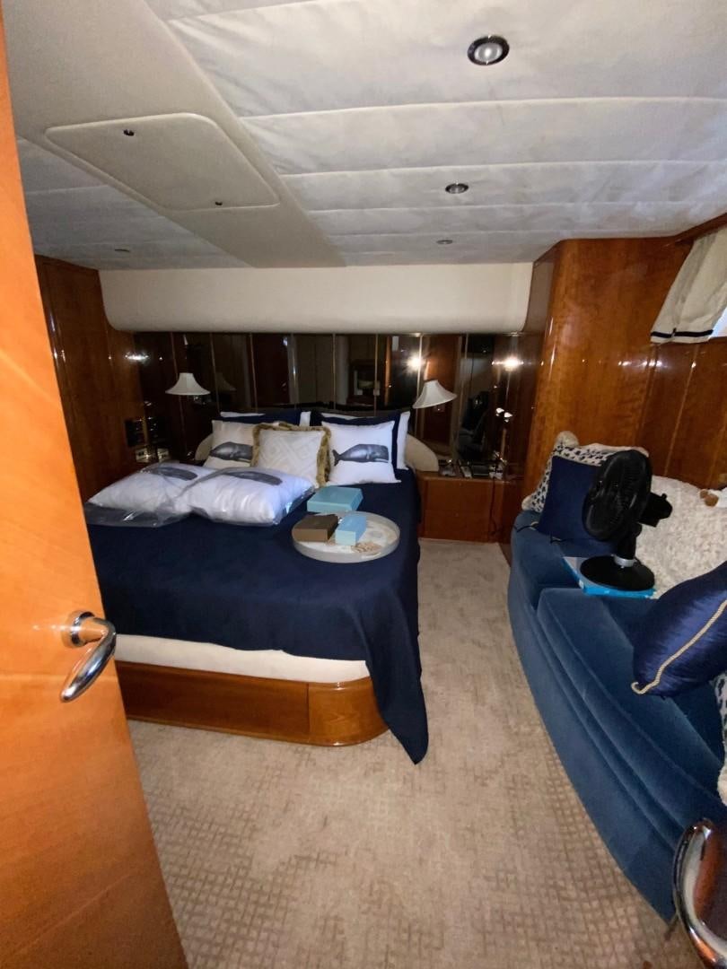 a bedroom with a bed and a blue couch aboard JOIE DU ROI Yacht for Sale