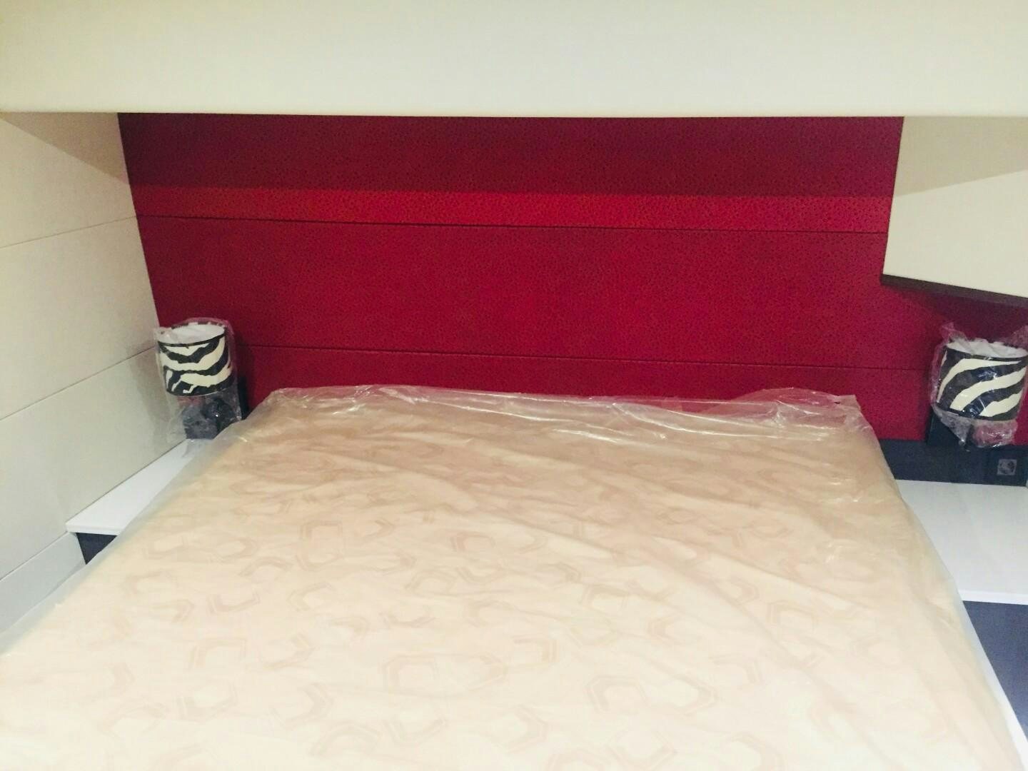 a bed with a red wall aboard SKYE Yacht for Sale
