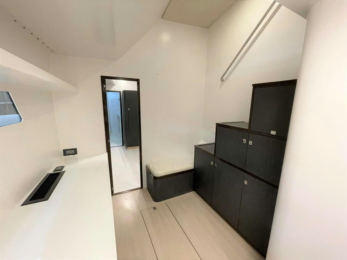 a room with a wood floor and a black cabinet with a black cabinet and a black cabinet with aboard SKYE Yacht for Sale