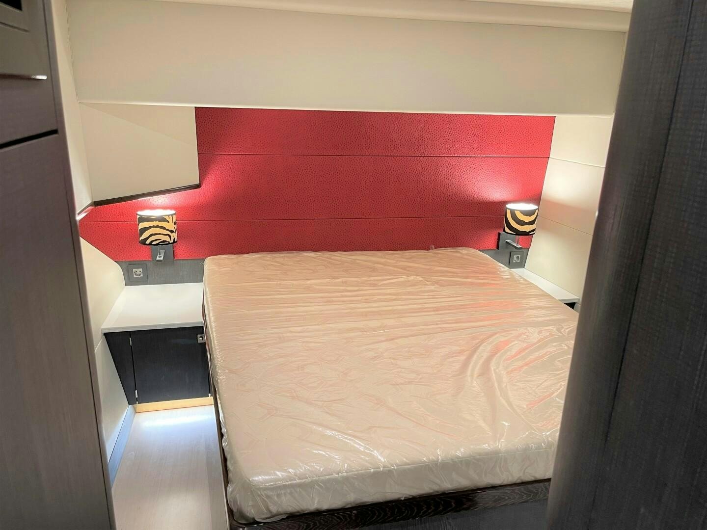 a bed with a red wall aboard SKYE Yacht for Sale