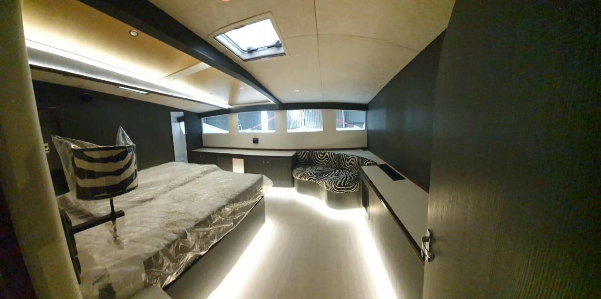 a room with a bed and a chair aboard SKYE Yacht for Sale