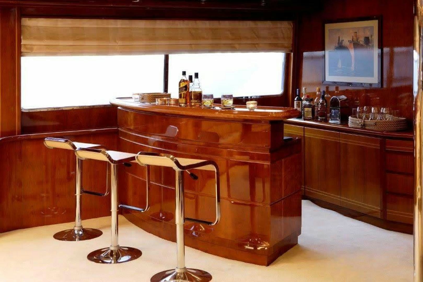 a bar with a bar and stools in it aboard CORVUS Yacht for Sale