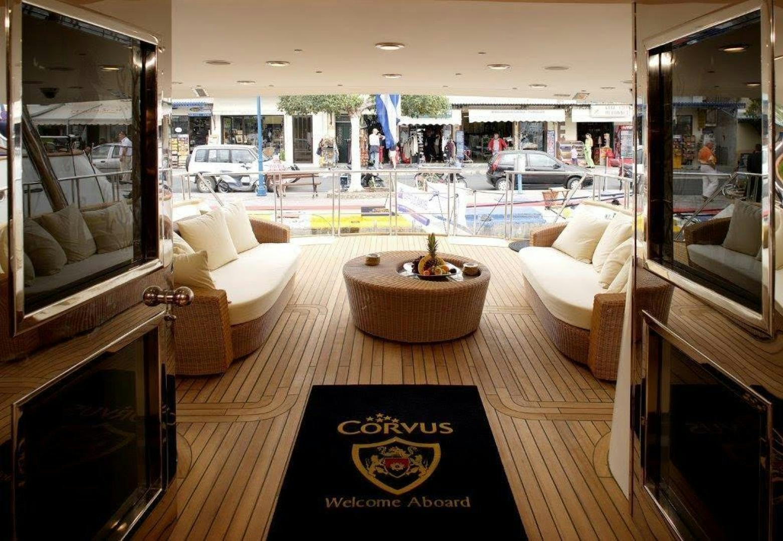 a room with a table chairs and a window with a sign aboard CORVUS Yacht for Sale