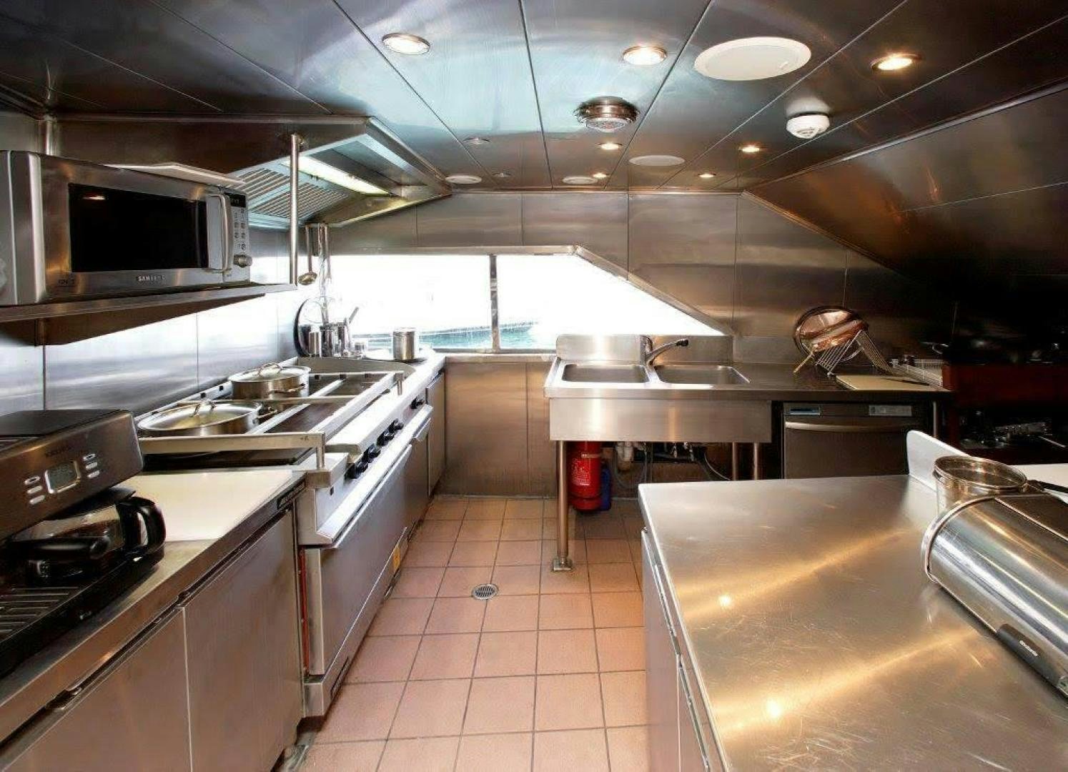 a kitchen with a large window aboard CORVUS Yacht for Sale