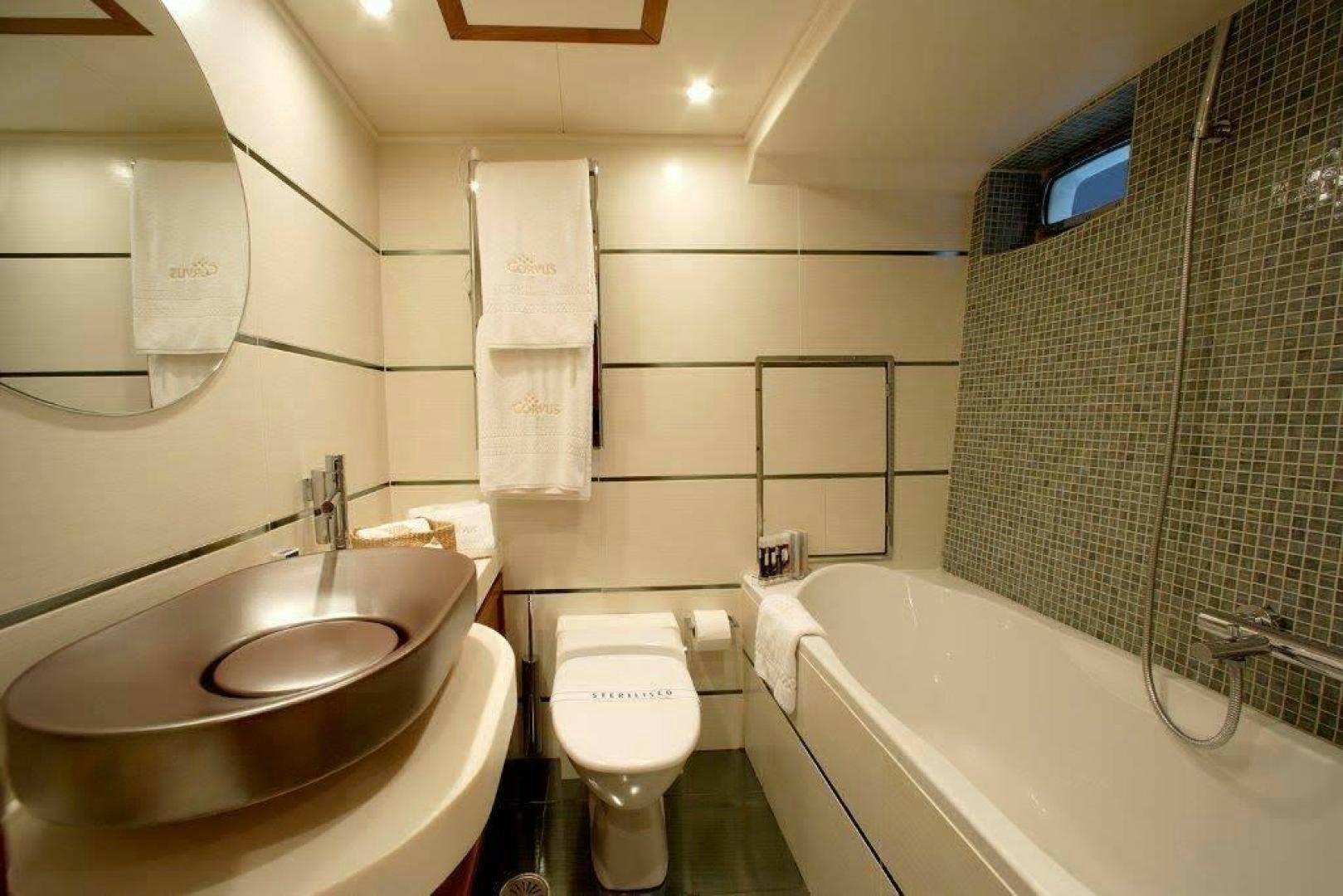 a bathroom with a sink toilet and bathtub aboard CORVUS Yacht for Sale