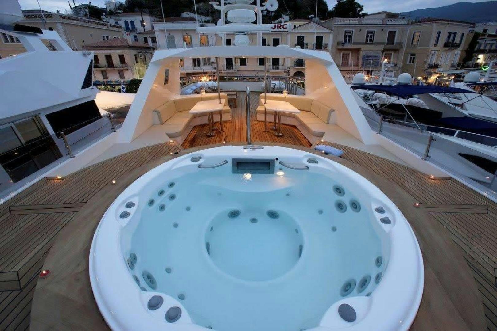 a large pool with a table and chairs in the background aboard CORVUS Yacht for Sale