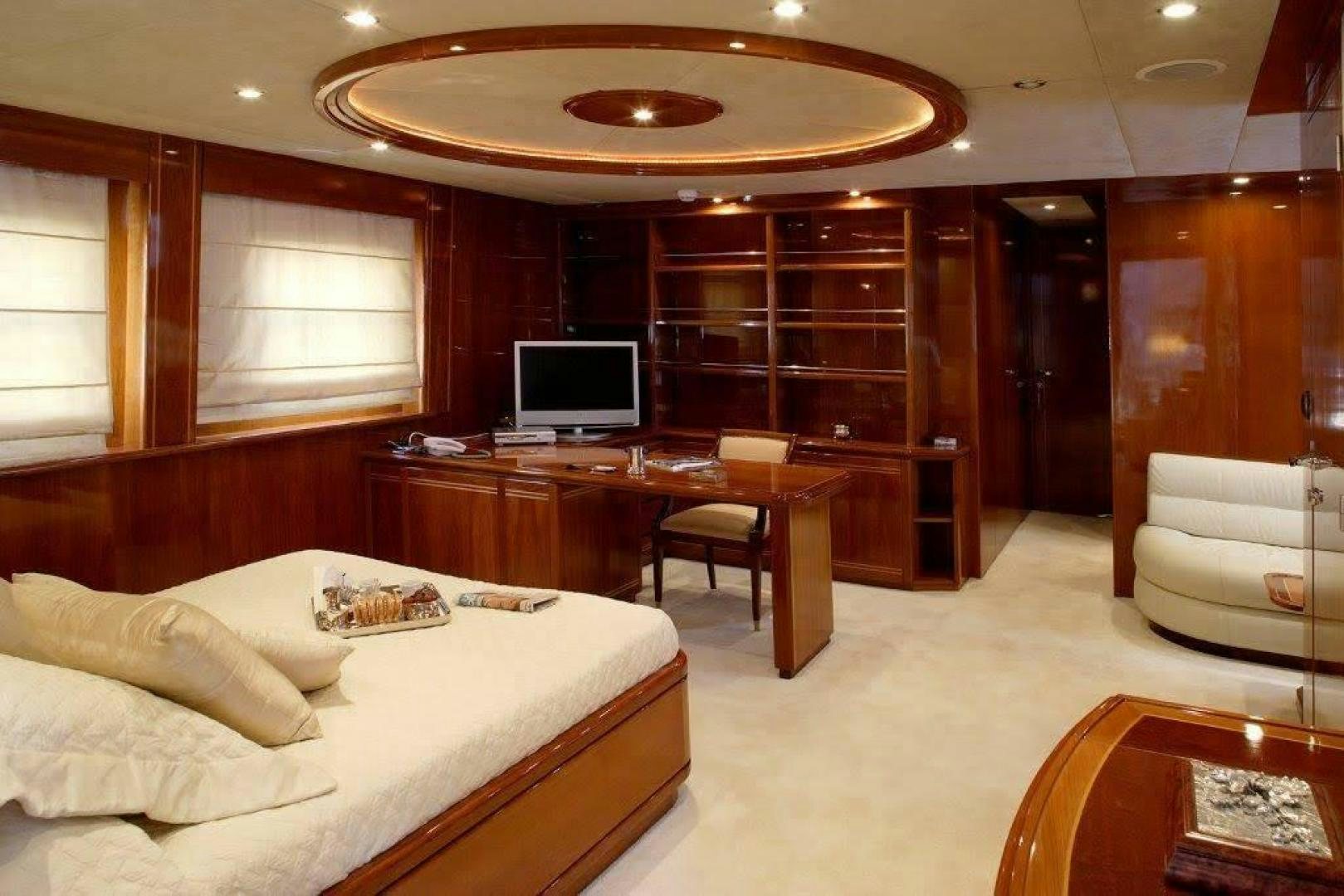 a hotel room with a bed and desk aboard CORVUS Yacht for Sale