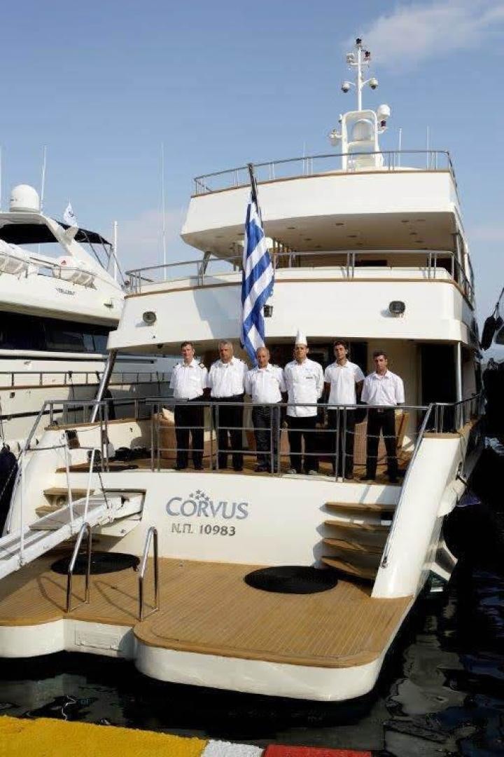 a group of people standing on a boat aboard CORVUS Yacht for Sale