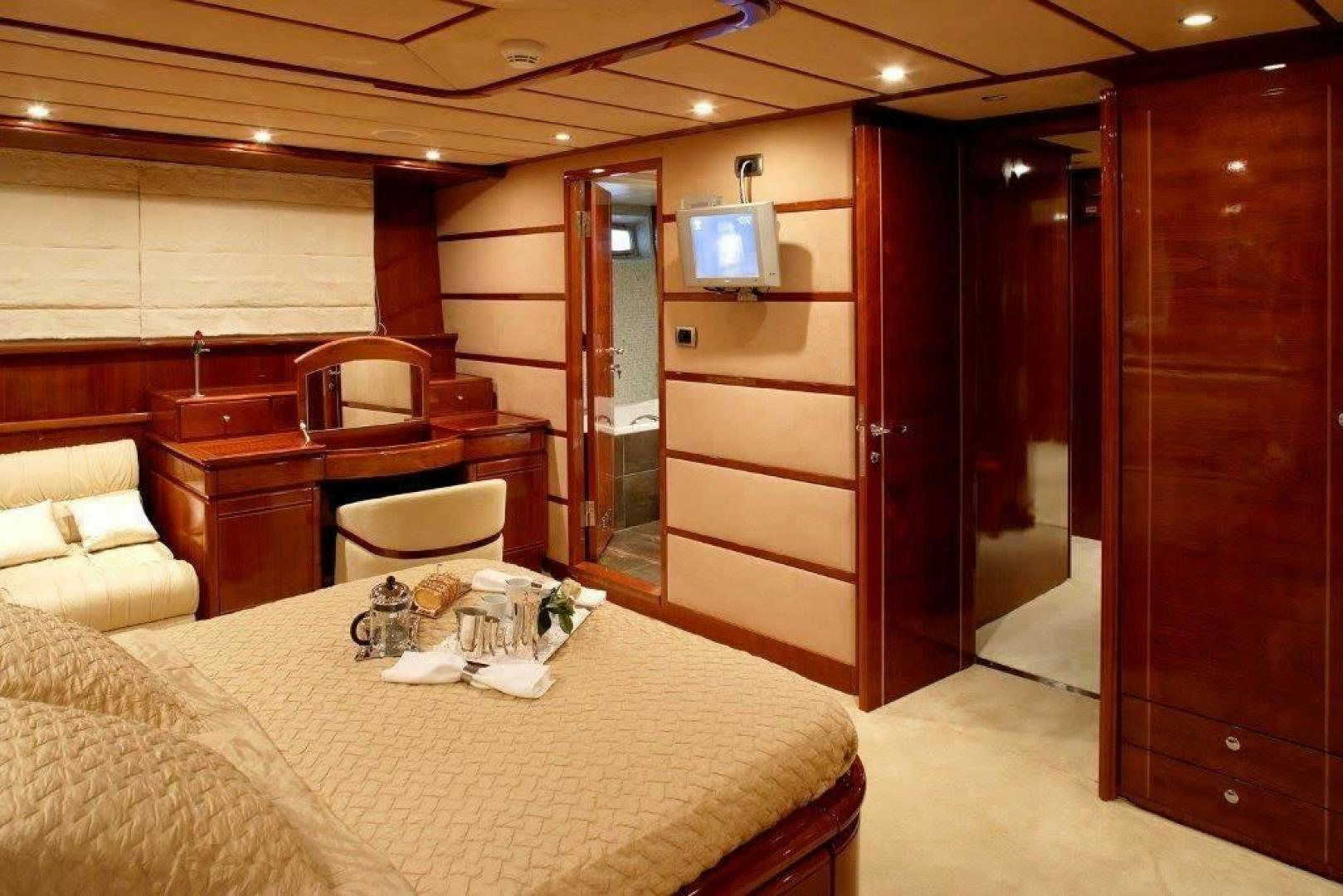 a room with a bed and a television aboard CORVUS Yacht for Sale