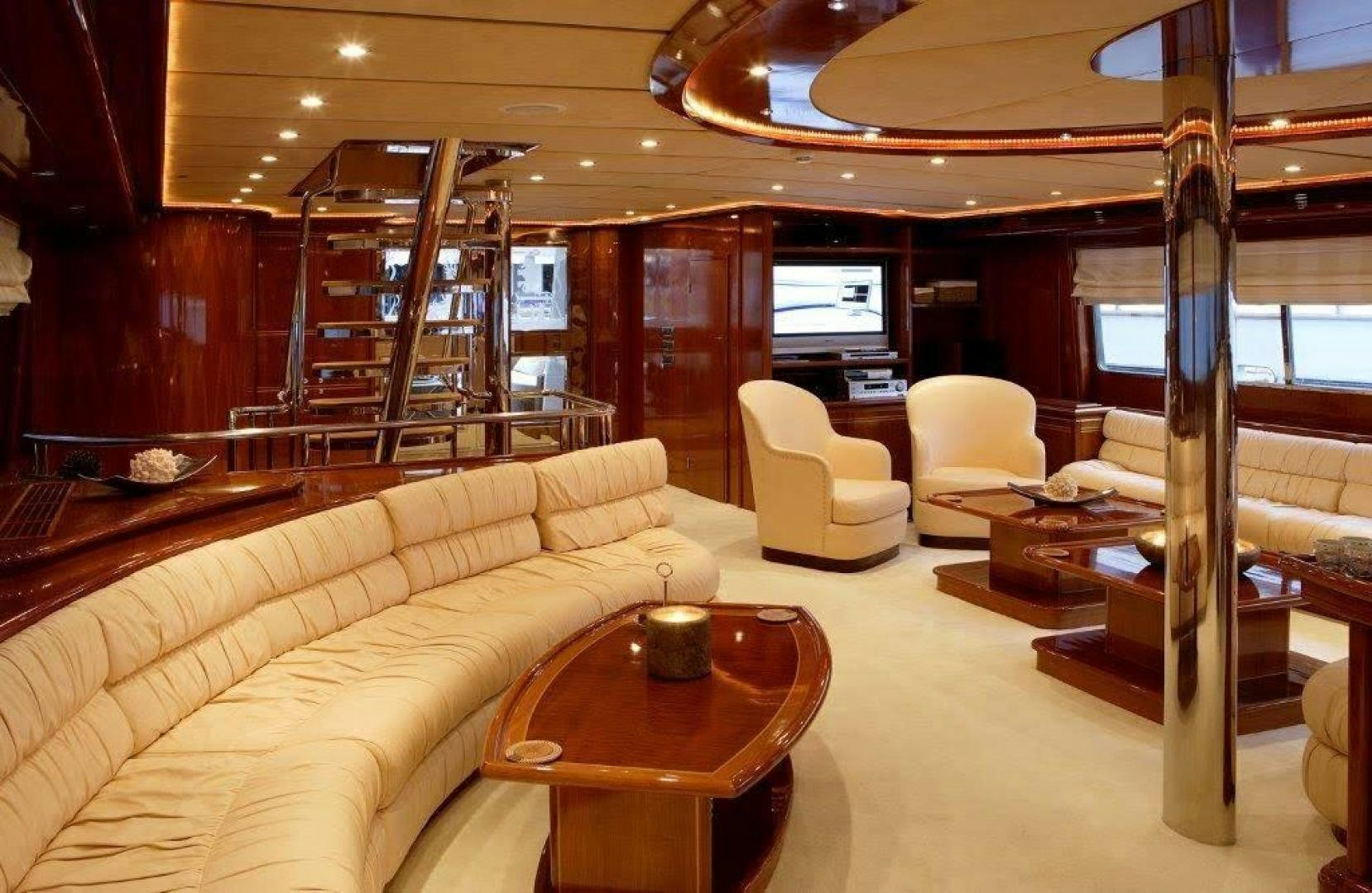 a living room with a large wood staircase aboard CORVUS Yacht for Sale