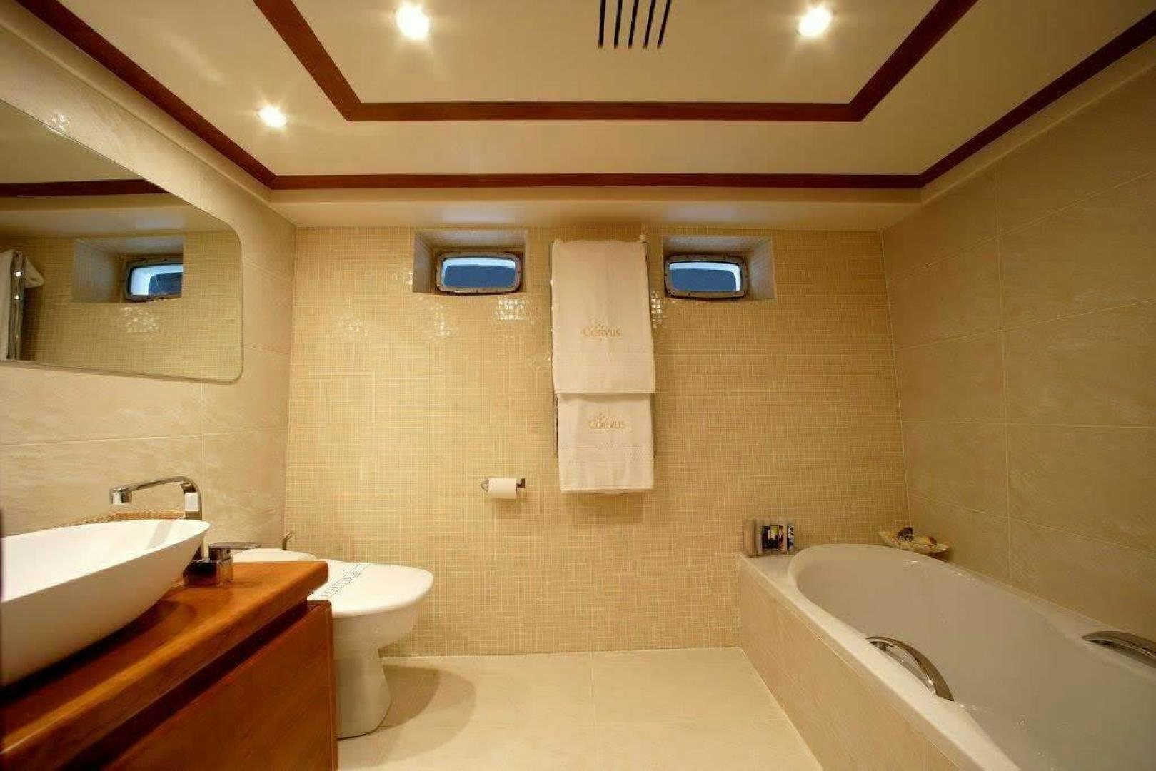 a bathroom with a tub sink and toilet aboard CORVUS Yacht for Sale