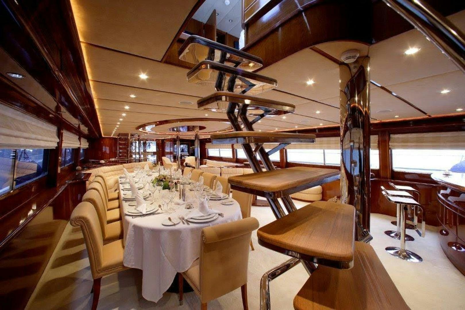 a room with tables and chairs aboard CORVUS Yacht for Sale