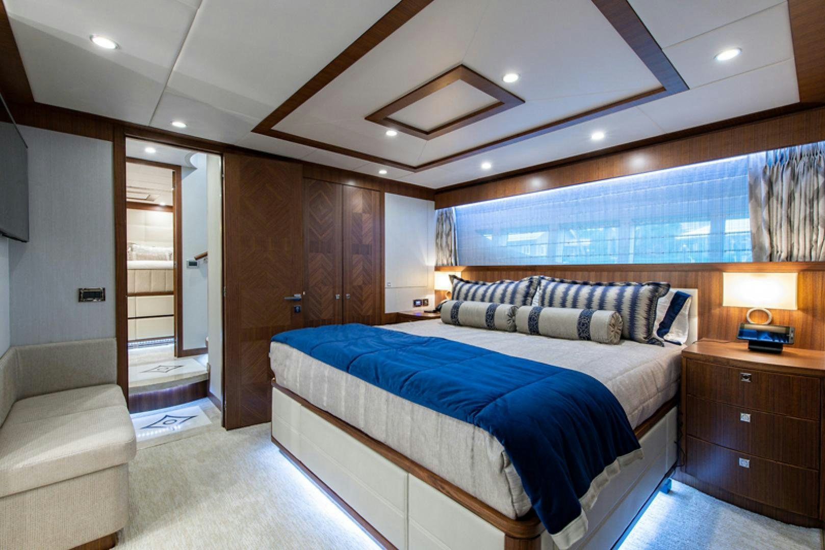 a bedroom with a bed and a wood door aboard GALATI G120 SIGNATURE SERIES Yacht for Sale