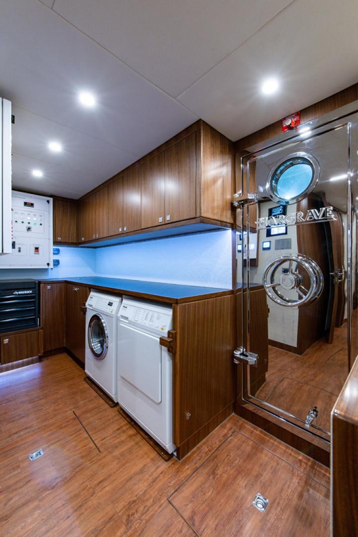 a kitchen with a washing machine and washer aboard GALATI G120 SIGNATURE SERIES Yacht for Sale