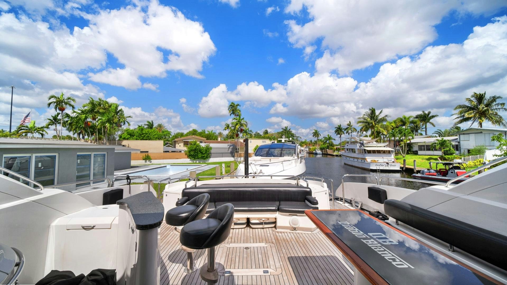 a deck with a chair on it and boats in the water aboard DIABLO BLANCO Yacht for Sale