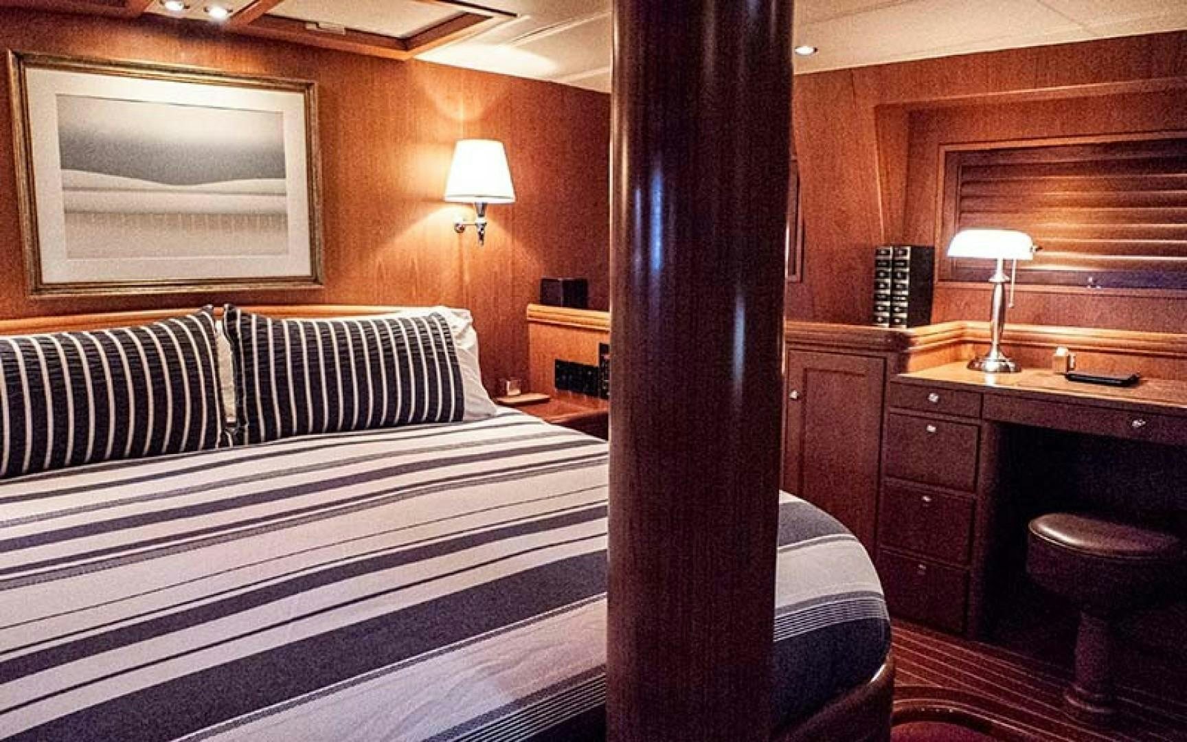 a bedroom with a bed and a desk aboard AVALON Yacht for Sale