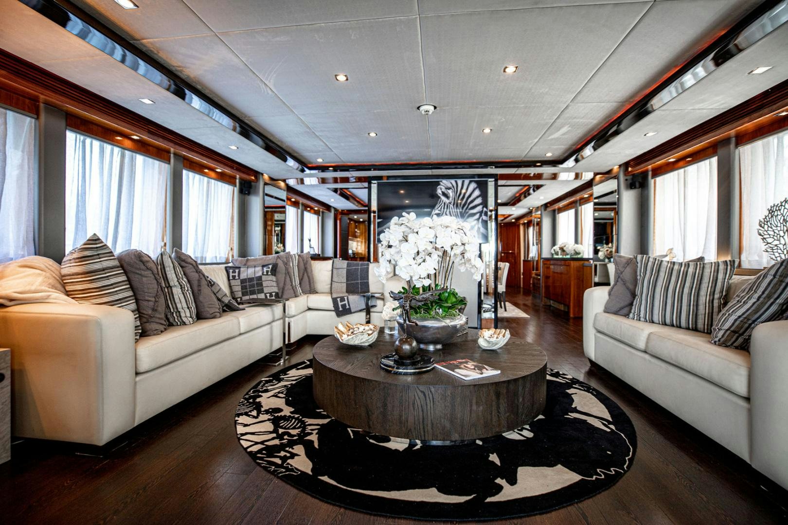 a living room with a large sofa and a coffee table aboard LE SORELLE III Yacht for Sale