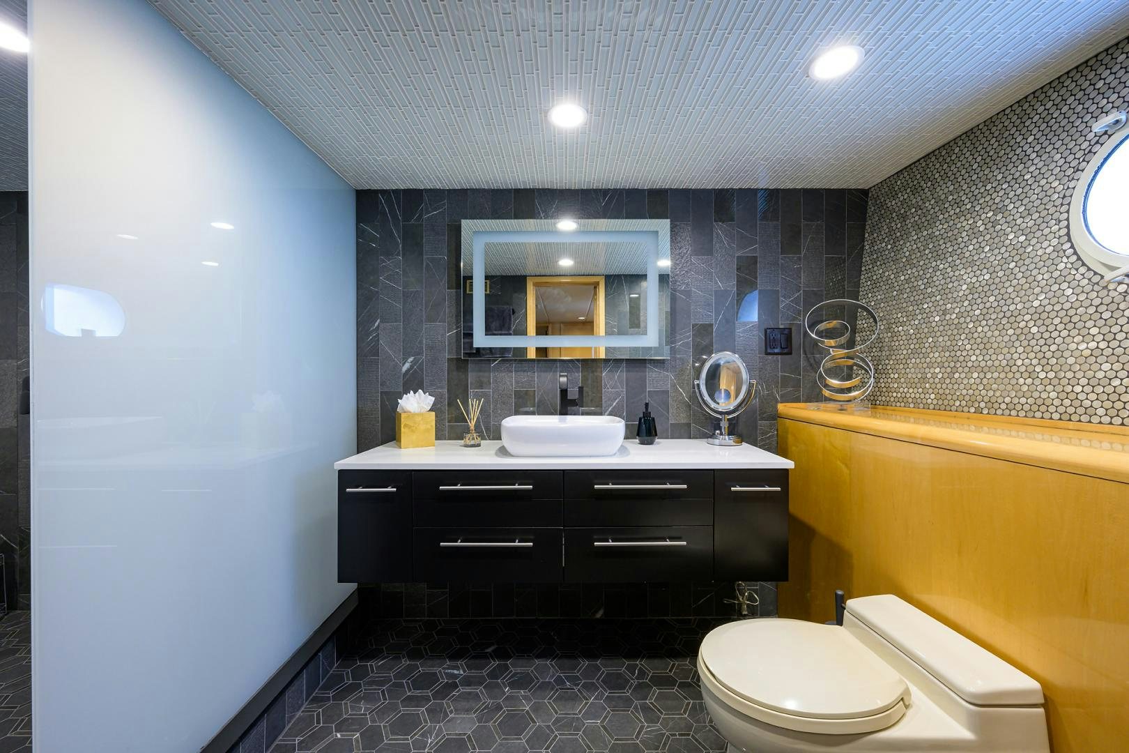 a bathroom with a sink toilet and a mirror aboard MEMORYMAKER Yacht for Sale