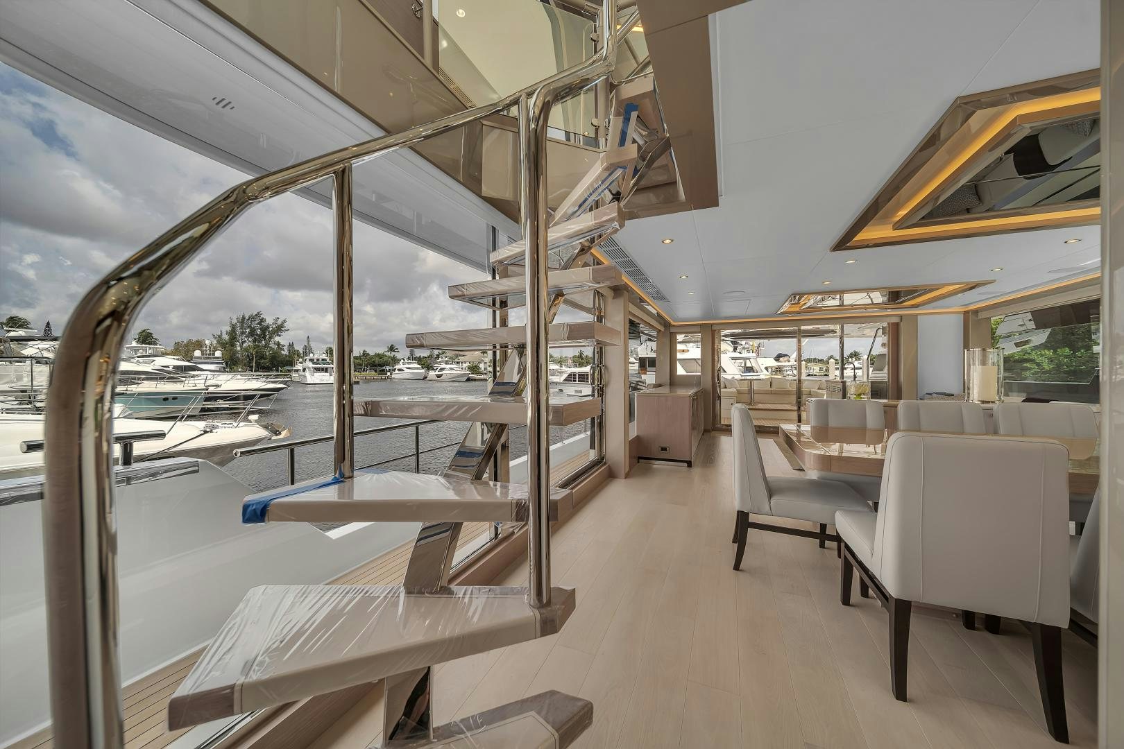 a room with a staircase and chairs aboard CARBON COPY Yacht for Sale