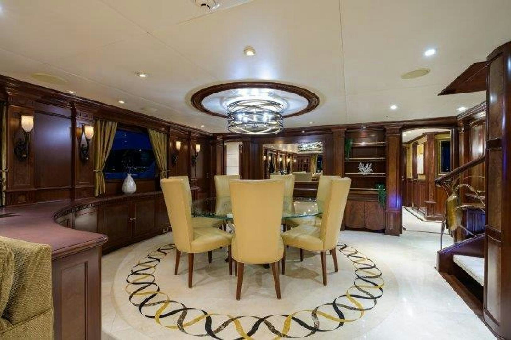 a room with a table chairs and a chandelier aboard UH OH Yacht for Sale