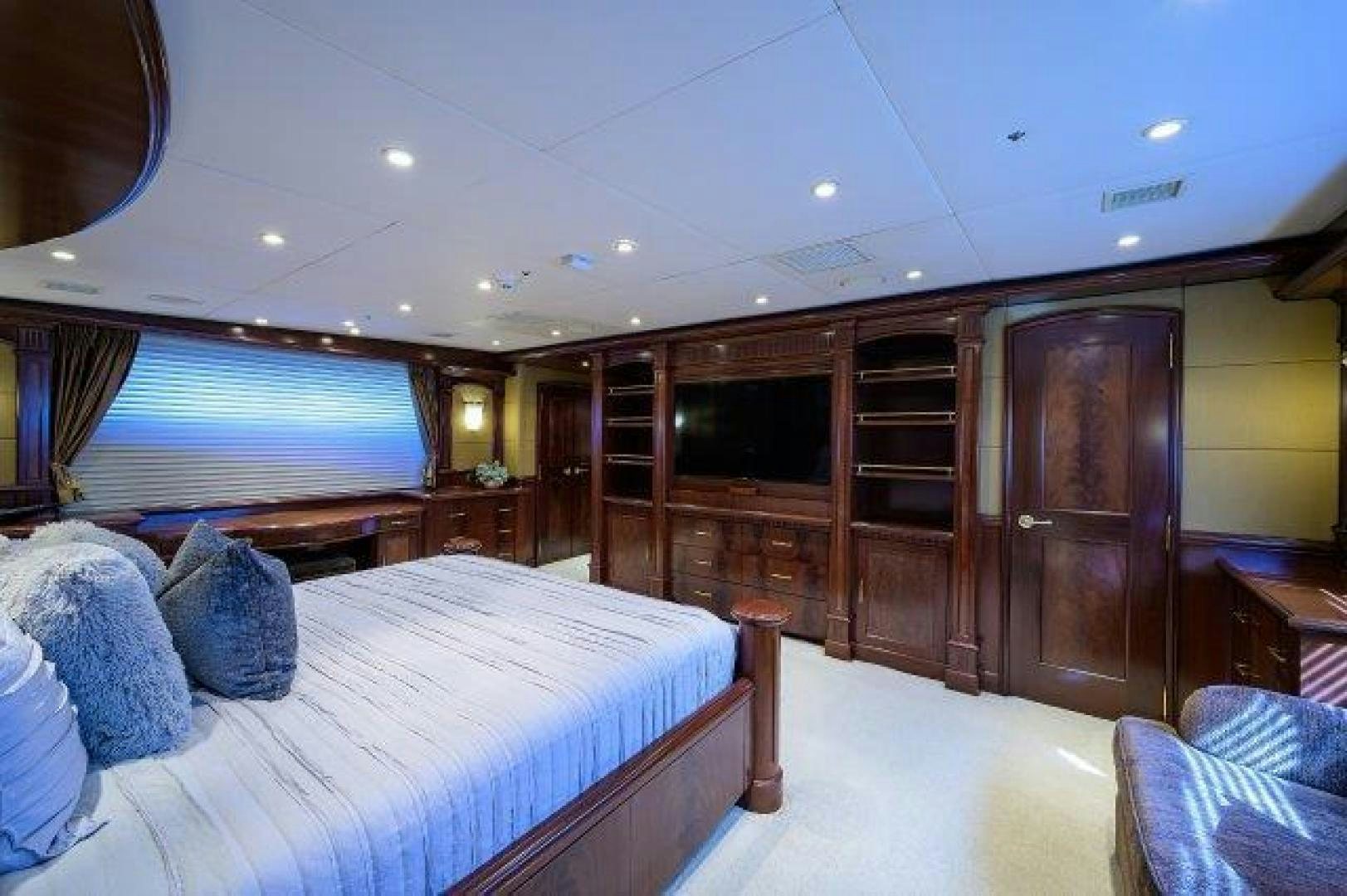 a bedroom with a bed and a wood cabinet aboard UH OH Yacht for Sale