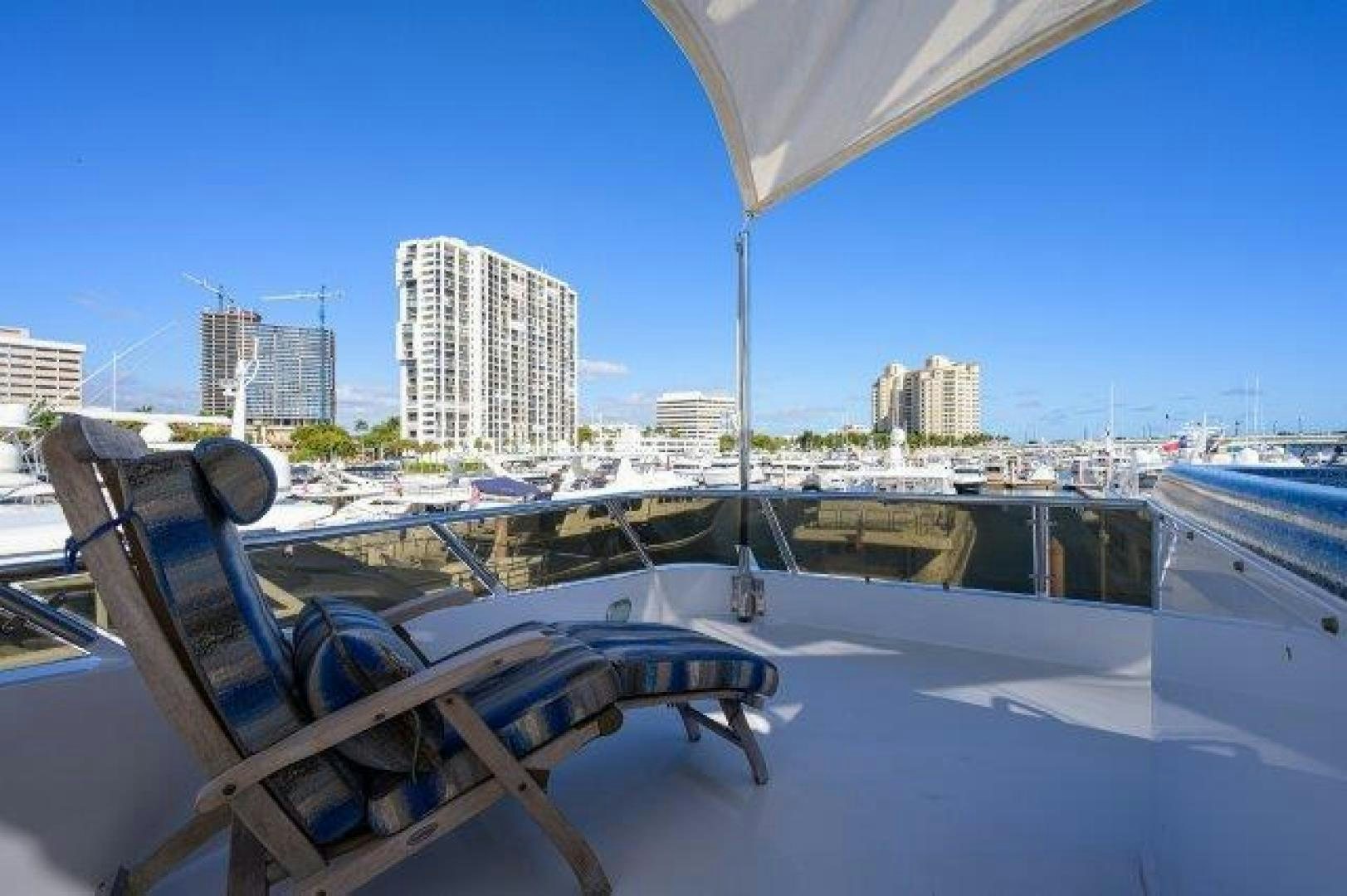 a lounge chair on a deck overlooking a city aboard UH OH Yacht for Sale