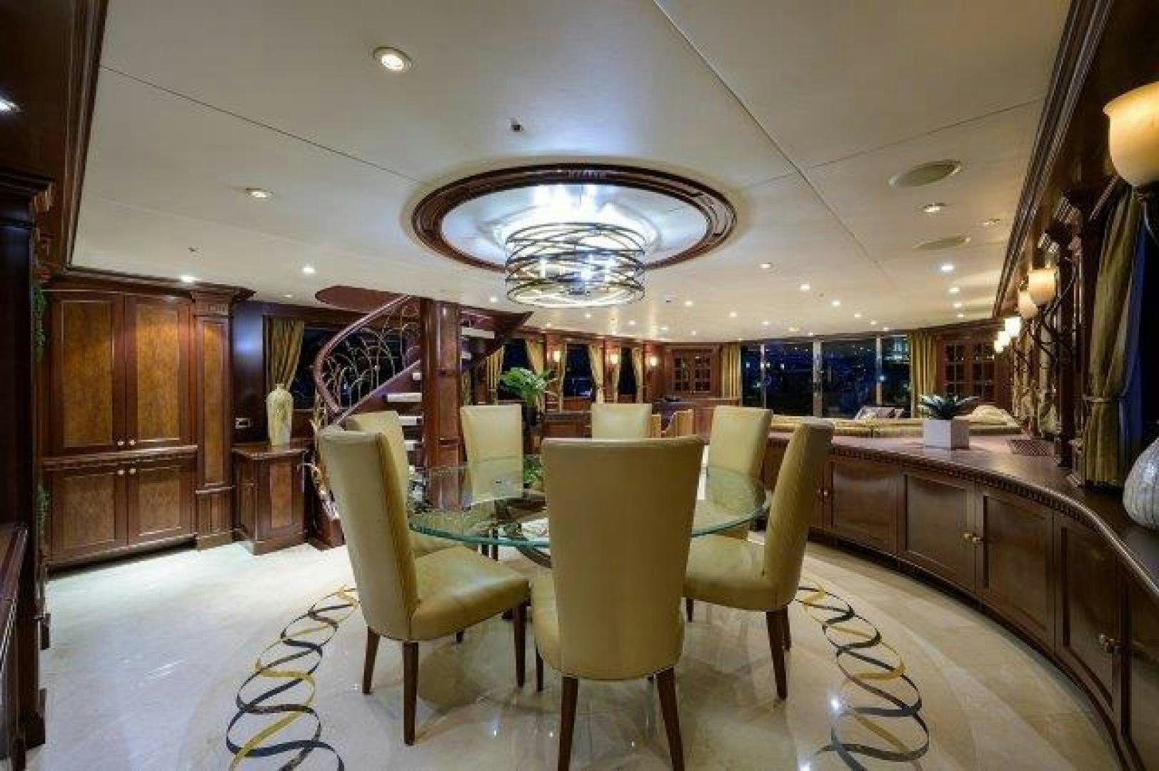 a room with a table chairs and a chandelier aboard UH OH Yacht for Sale