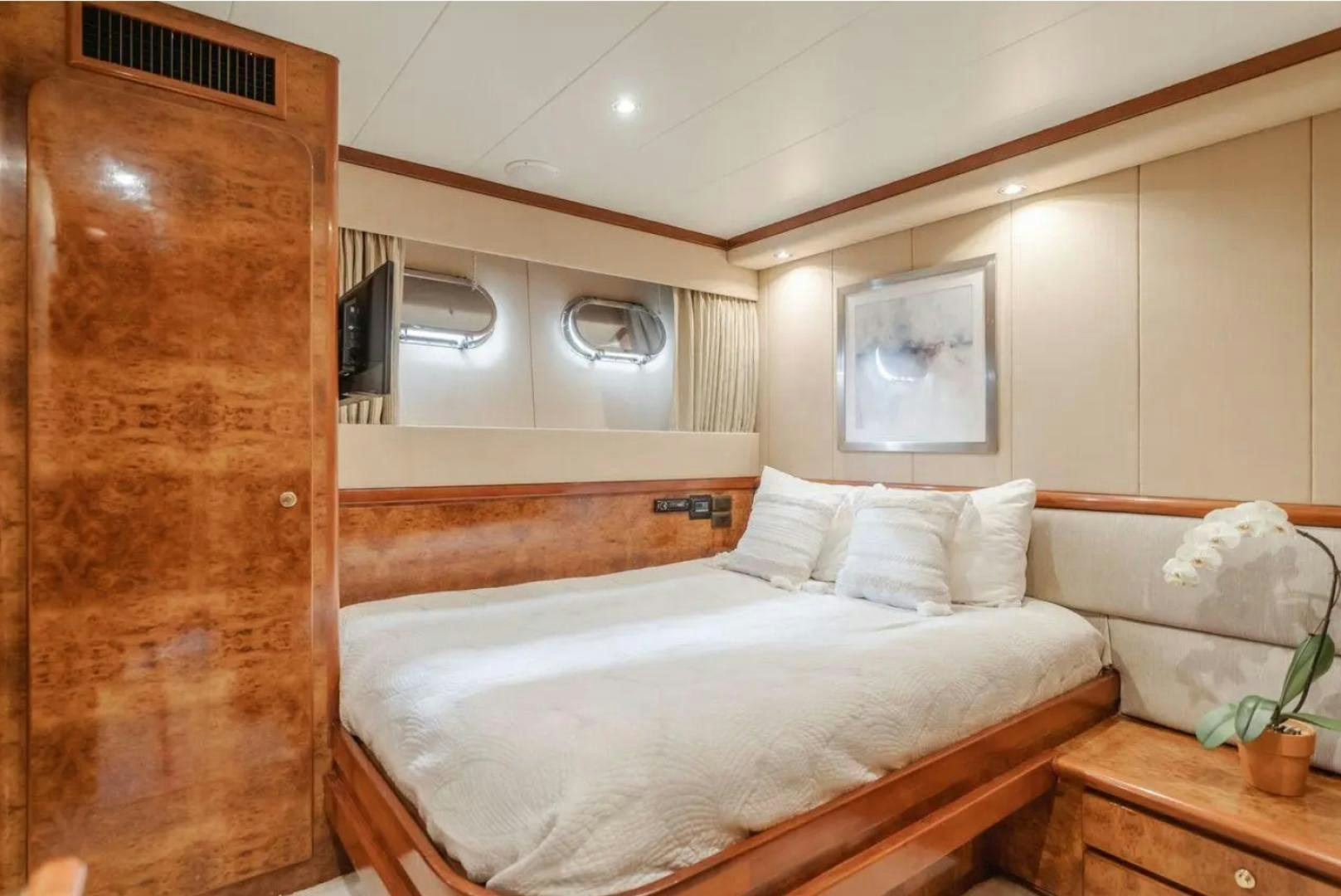 a room with a bed and a wood cabinet aboard MARBELLA Yacht for Sale