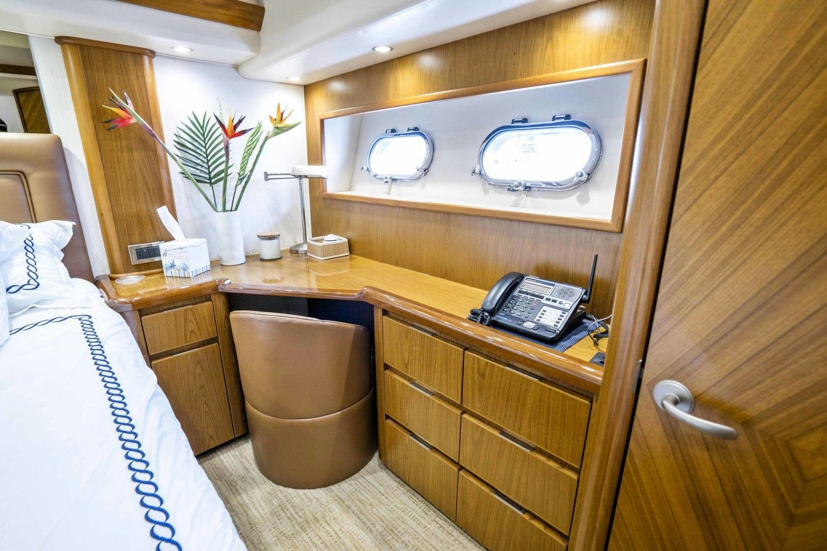 a room with a bed and a phone on a desk aboard LAST CALL Yacht for Sale