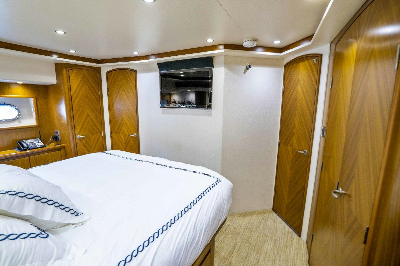 a bedroom with a bed and a television aboard LAST CALL Yacht for Sale