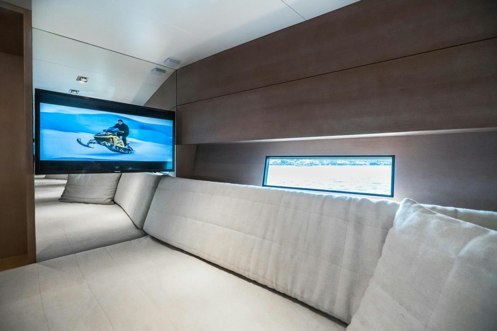 a room with a couch and a television on the wall aboard ASH Yacht for Sale
