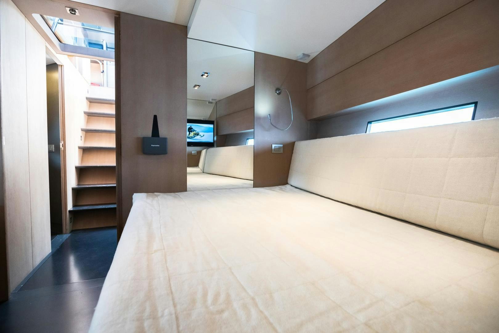 a room with a bed and a tv on the wall aboard ASH Yacht for Sale