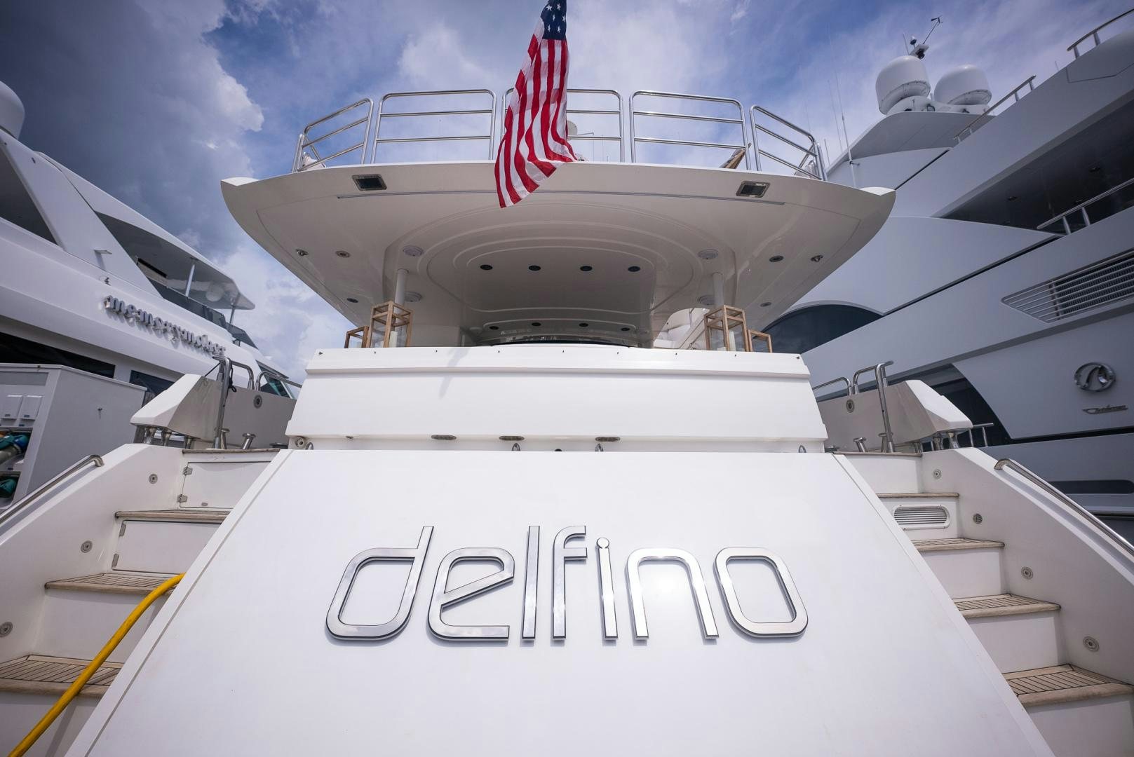 a large white ship with a red flag on the front aboard DELFINO Yacht for Sale