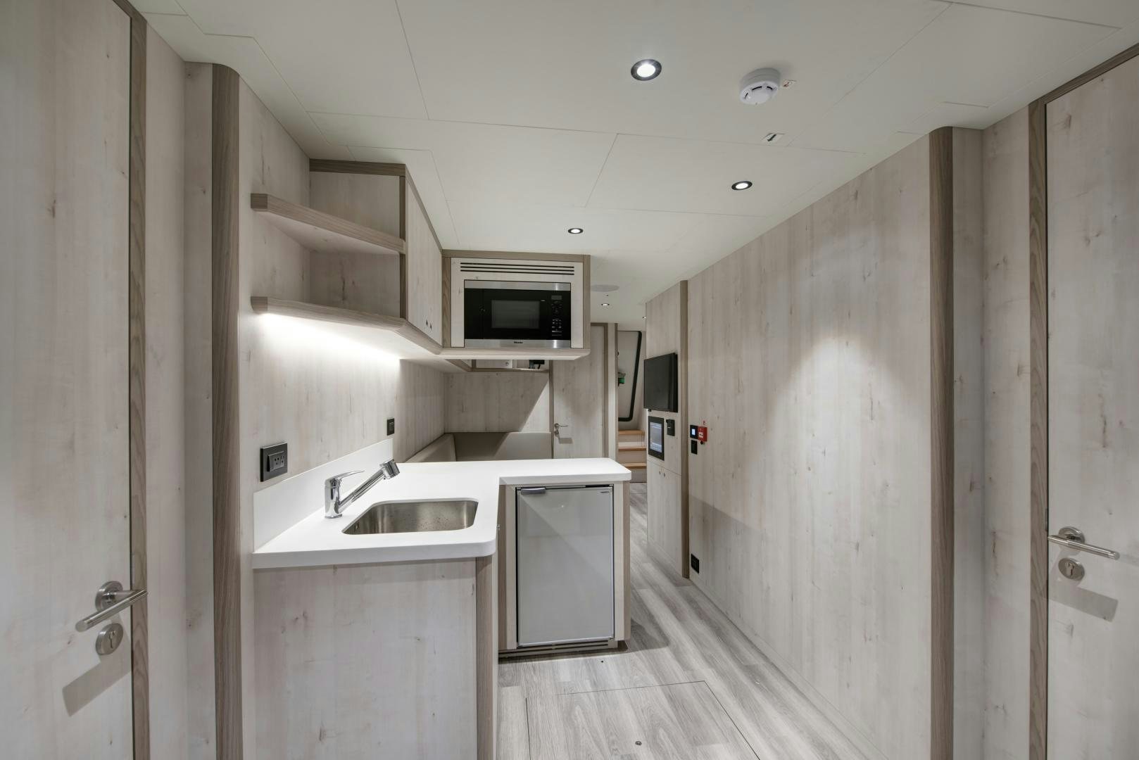 a kitchen with white cabinets aboard ALFRESCO 125 Yacht for Sale