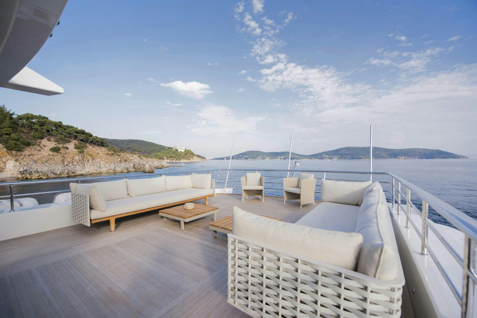 a deck with chairs and a body of water in the background aboard ALFRESCO 125 Yacht for Sale