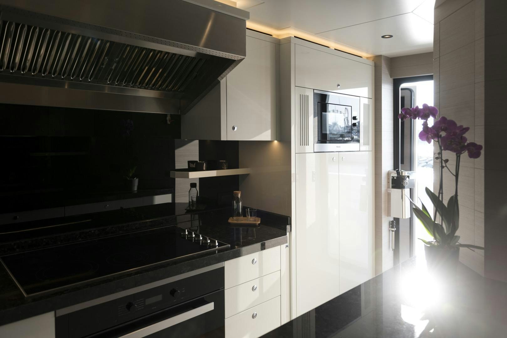 a kitchen with a black counter top aboard ALFRESCO 125 Yacht for Sale