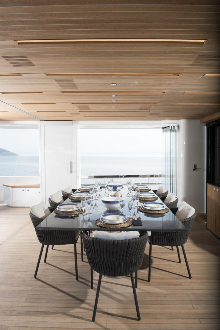 a large dining table with chairs aboard ALFRESCO 125 Yacht for Sale