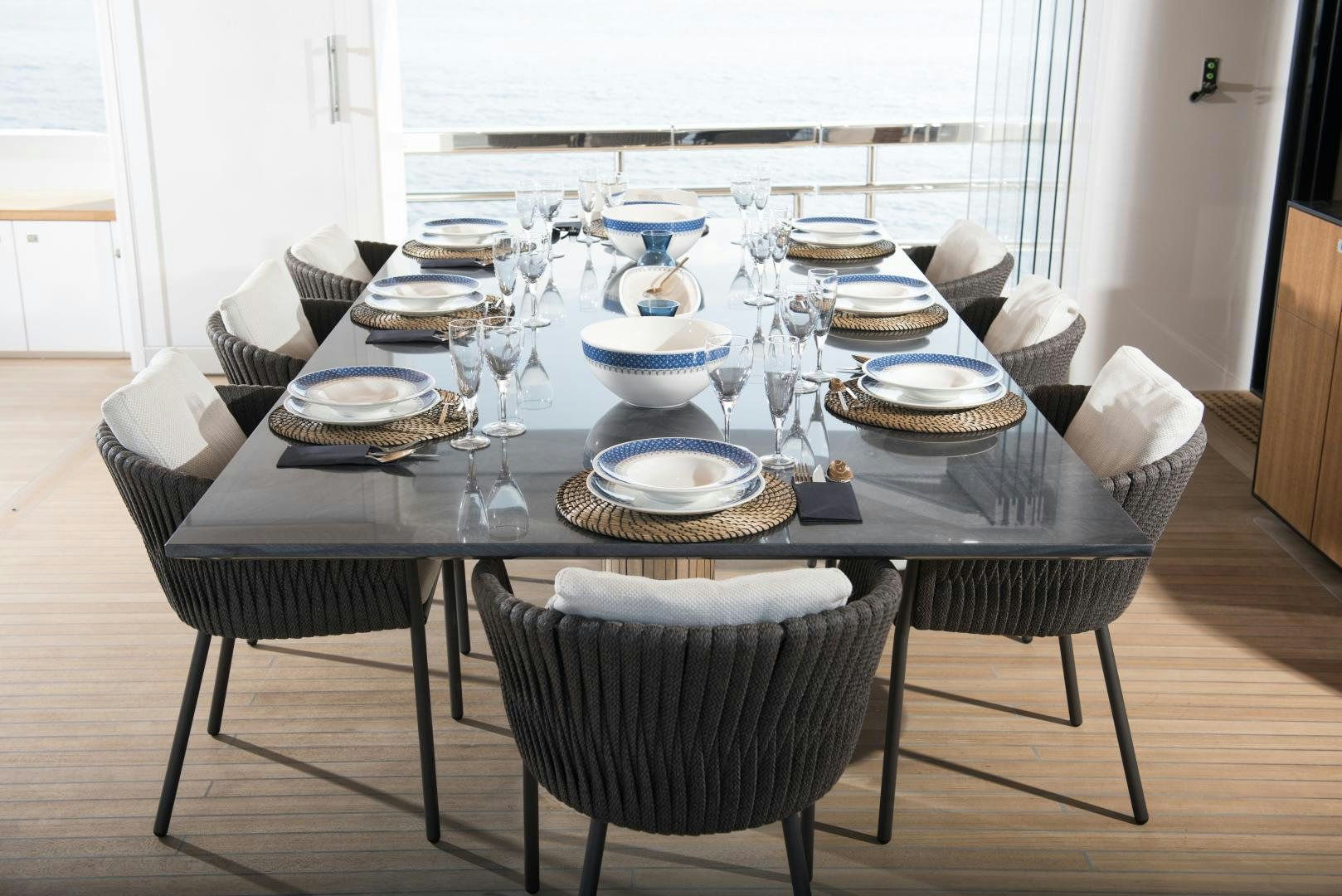 a table with plates and cups on it aboard ALFRESCO 125 Yacht for Sale