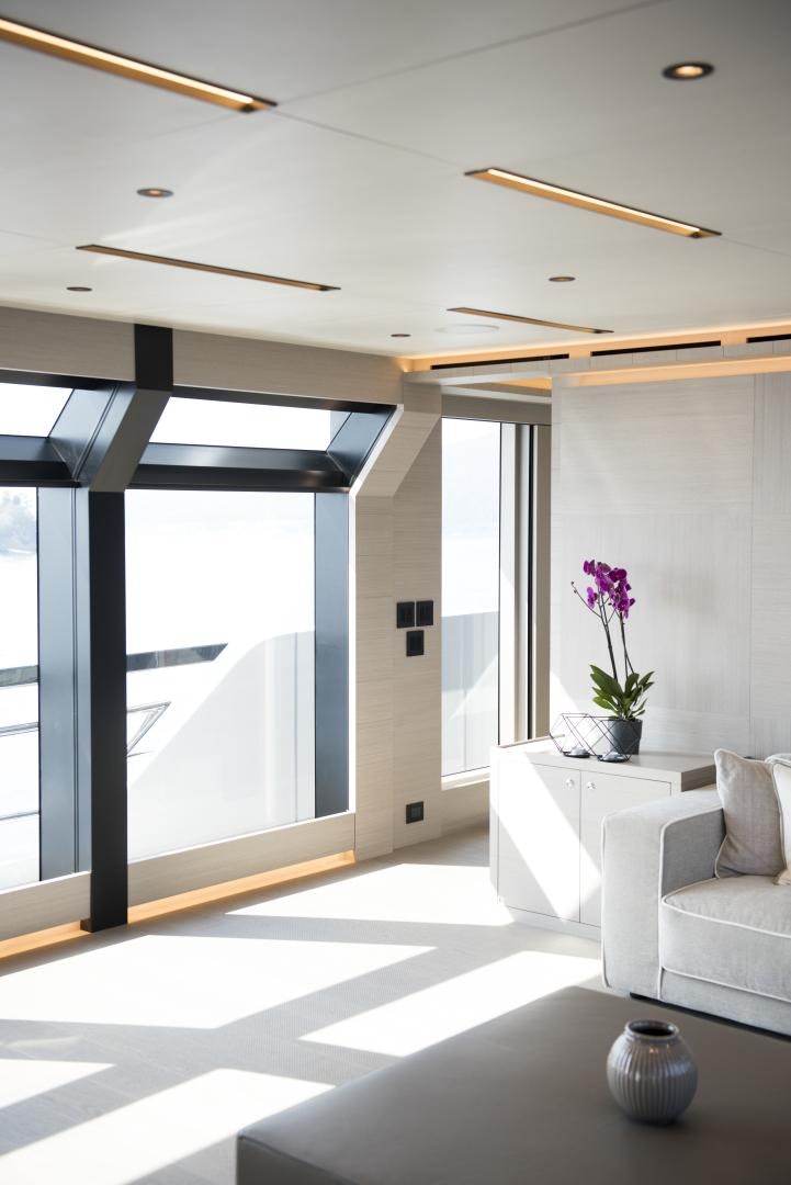 a room with a large glass door and a white sofa aboard ALFRESCO 125 Yacht for Sale